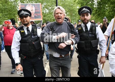 La police a menottant et a mis un manifestant à Hyde Park à Londres après l'introduction de mesures pour faire sortir le pays du confinement. Banque D'Images