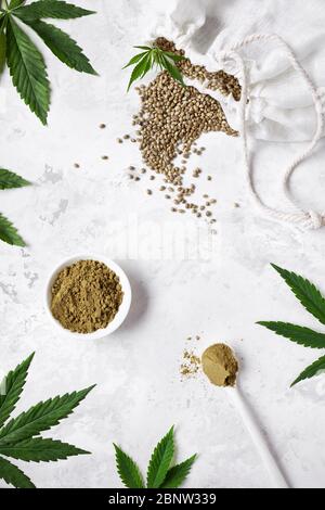 Graines de chanvre et poudre de protéine de chanvre sur fond blanc autour des feuilles de cannabis plat. Idéal pour un régime alimentaire commencé Banque D'Images