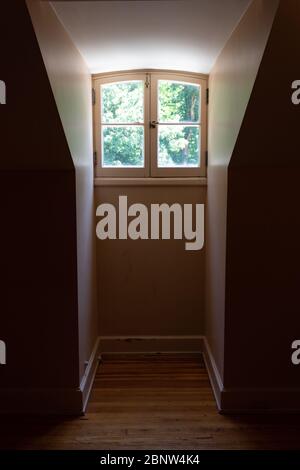 Vue intérieure d'une fenêtre de dormeur et ouverture très étroite dans une pièce sombre, aspect vertical Banque D'Images