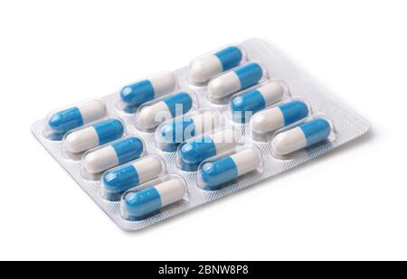 Capsules blanches et bleues en blister isolé sur blanc Banque D'Images