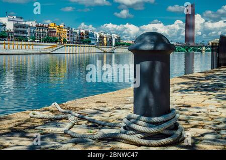 Bollard avec une corde d'amarrage sans bateau pendant la pandémie du coronavirus à Séville. Banque D'Images