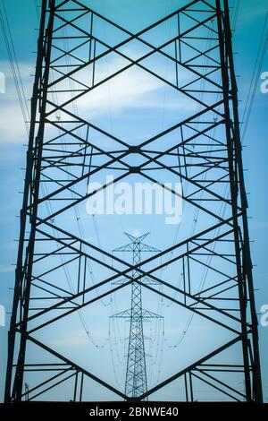 Ligne de transmission haute tension contre ciel bleu Banque D'Images