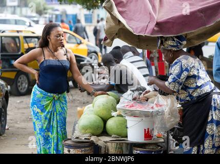 Une femme attend d'être servie sur un marché fruitier à Dakar, Sénégal, Afrique de l'Ouest. Banque D'Images