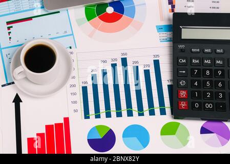 Espace de travail avec une calculatrice et des diagrammes sur la table de près. Vue de dessus d'une mise en page à plat. Travail à domicile, indépendant. Concept d'entreprise et comptabilité Banque D'Images