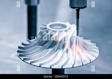 Inspection de l'opérateur des pièces métalliques de dimension par la DCGM après usinage dans une usine industrielle. Banque D'Images