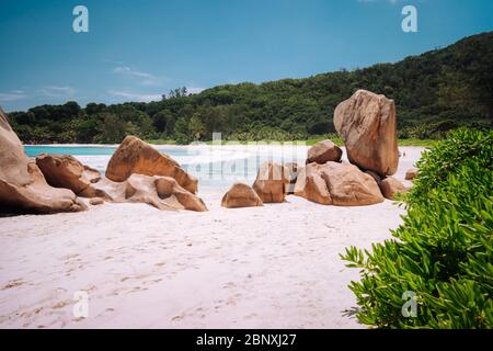 Des rochers en granit magnifiquement façonnés dans le lagon turquoise de l'océan et un sable blanc parfait à l'Anse Coco, île de la Digue, Seychelles Banque D'Images