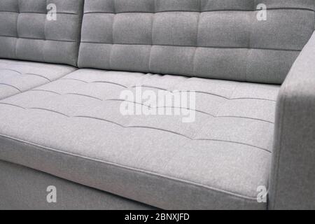 Vue sur le canapé moderne en tissu gris. Gros plan Banque D'Images