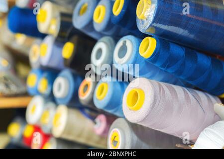 Fil de couleur sur bobines dans un atelier de couture. Concept de l'industrie du vêtement Banque D'Images