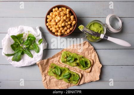 Deux crackers avec humus aux épinards verts sur table en bois. Pose plate. Concept de houmous. Photographie alimentaire Banque D'Images