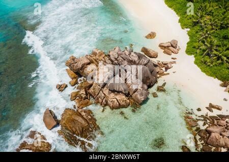 Seychelles l'île de la Digue. Vue aérienne sur les vagues de l'océan et les rochers en granit énormes sur la plage tropicale anse cocos avec eau turquoise azur. Vacances Banque D'Images