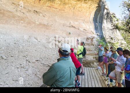 Touristes regardant les divers pictogrammes de peinture murale Navajo au refuge Fate Bell, dans le canyon Seminole, Texas Banque D'Images