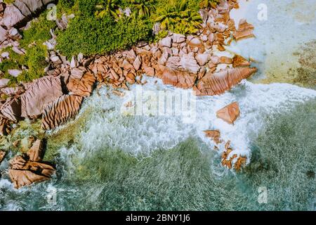 Seychelles l'île de la Digue. Vue aérienne sur les vagues de l'océan et les énormes rochers de granit bizarres sur la plage tropicale anse cocos avec eau turquoise azur Banque D'Images