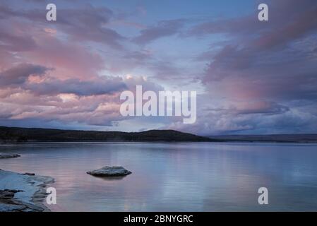 WY04390-00...WYOMING - coucher de soleil sur le lac Yellowstone et le cône de pêche au bassin West Thumb Geyser dans le parc national de Yellowstone. Banque D'Images