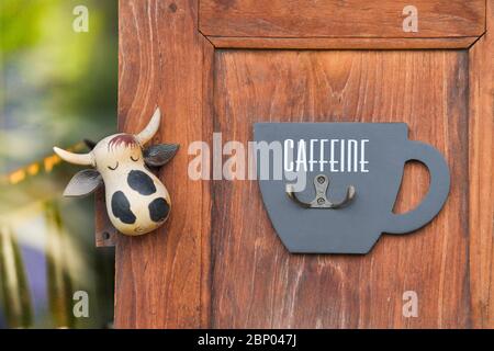 Ouvre-bouteille et poupée de vache sur un mur en bois Banque D'Images