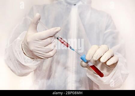 Les technologistes médicaux injectent du sang dans une sonde de test dans un laboratoire scientifique en analysant les résultats sanguins pour les médicaments antirétroviraux. Concept de Banque D'Images