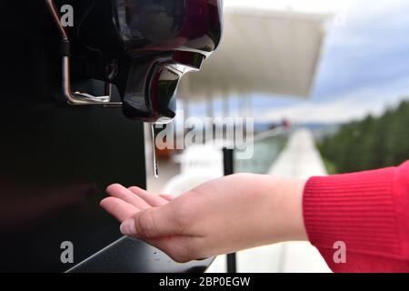 Les clients du restaurant se lavant les mains à l'aide d'un désinfectant automatique à base de gel. Prévention des coronavirus dans un restaurant de caffee pendant la corona viru Banque D'Images