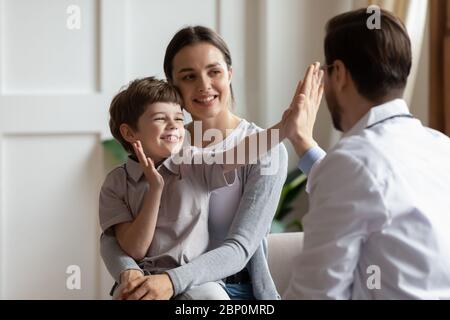 Joyeux petit garçon saluant le patient avec un pédiatre à l'examen Banque D'Images