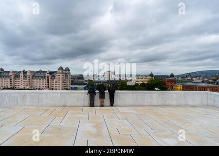 Trois voyageurs apprécient la vue magnifique de l'opéra national norvégien et du bâtiment du Ballet à Oslo. Août 2019 Banque D'Images