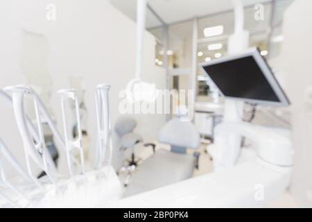 Chaise dentaire moderne et vierge floue avec équipement professionnel Banque D'Images