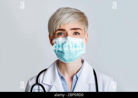 Concept de santé et de médecine. Portrait d'un thérapeute sympathique dans un masque de protection, gros plan Banque D'Images