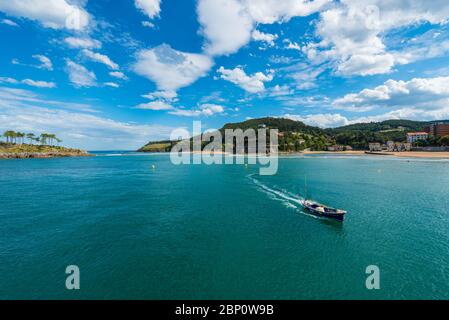 Un bateau entre l'embouchure de la rivière Lea et l'île de San Nicolas à Lekeitio Banque D'Images