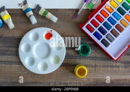 Pose plate de couleur aquarelle colorée et palette à gros plan sur un bureau en bois, un espace de travail artistique. Vue de dessus. Banque D'Images