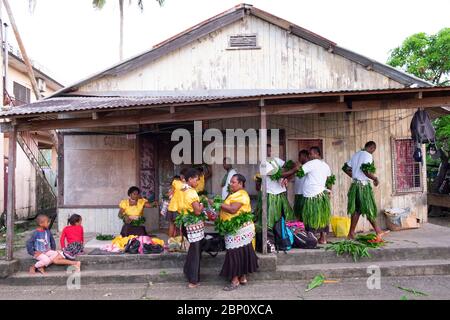 Hommes et femmes s'aident mutuellement pour une cérémonie traditionnelle à Sigatoka (Singatoka), Fidji. Banque D'Images