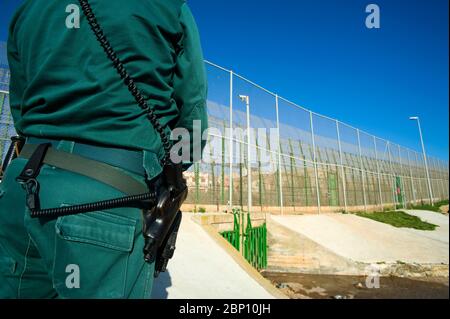 MELILLA,ESPAGNE-AVRIL 19 : UN Guardia civil se trouve près de la clôture périphérique qui sépare l'enclave espagnole de Melilla et du Maroc le 19,2010 avril à Melilla, Espagne. La clôture qui marque la frontière autour de l'enclave espagnole dans le nord du Maroc a été construit pour décourager les immigrants illégaux d'essayer d'entrer à Melilla. ( photo de Jordi Cami) Banque D'Images