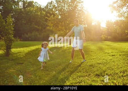 Fête des pères. Le père joue avec sa fille dans le parc d'été. Banque D'Images