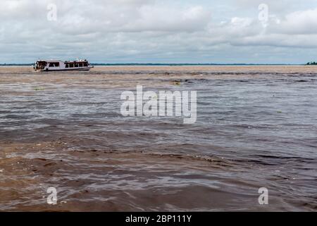 Bateau à vitesse avec les touristes regardant l'Encontro das águas, la rencontre des eaux, le fleuve Amzon, Manaus, l'État d'Amazone, Brésil, Amérique latine Banque D'Images