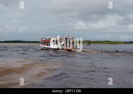 Bateau à vitesse avec les touristes regardant l'Encontro das águas, la rencontre des eaux, le fleuve Amzon, Manaus, l'État d'Amazone, Brésil, Amérique latine Banque D'Images