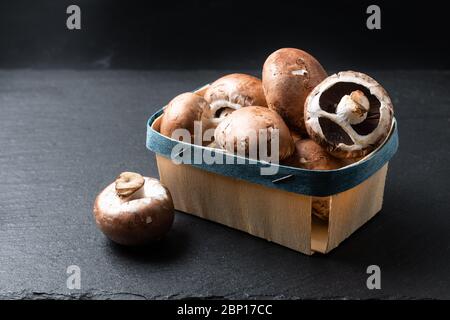 Helahy Food concept champignons Cremini-bruns bio sur fond de tableau d'ardoise noire avec espace de copie Banque D'Images