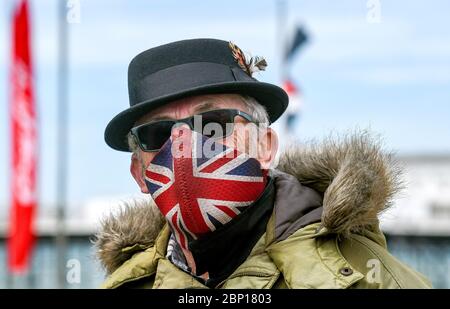 Brighton Royaume-Uni 17 mai 2020 - UN Mod portant un masque Union Jack sur le front de mer de Brighton, assez calme aujourd'hui à l'heure du déjeuner, par une chaude journée avec un mélange de soleil et de nuages le premier week-end après que les gouvernements aient eu un léger assouplissement des restrictions de verrouillage en Angleterre pendant La pandémie du coronavirus COVID-19 . Crédit : Simon Dack / Alamy Live News Banque D'Images