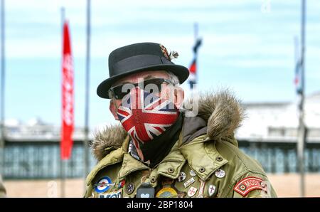 Brighton Royaume-Uni 17 mai 2020 - UN Mod portant un masque Union Jack sur le front de mer de Brighton, assez calme aujourd'hui à l'heure du déjeuner, par une chaude journée avec un mélange de soleil et de nuages le premier week-end après que les gouvernements aient eu un léger assouplissement des restrictions de verrouillage en Angleterre pendant La pandémie du coronavirus COVID-19 . Crédit : Simon Dack / Alamy Live News Banque D'Images