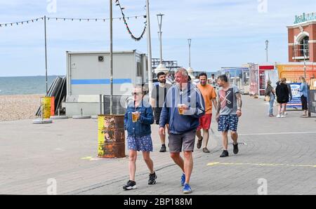 Brighton Royaume-Uni 17 mai 2020 - On pouvait prendre des bières et des boissons à emporter le long du front de mer de Brighton, qui était assez calme aujourd'hui à l'heure du déjeuner, par une chaude journée avec un mélange de soleil et de nuages le premier week-end après que les gouvernements aient eu un léger assouplissement des restrictions de verrouillage en Angleterre pendant La pandémie du coronavirus COVID-19 . Crédit : Simon Dack / Alamy Live News Banque D'Images