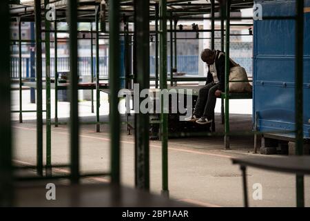 Un homme est assis dans le marché ouvert des arènes désertés de Birmingham, après l'introduction de mesures pour sortir le pays du confinement. Banque D'Images