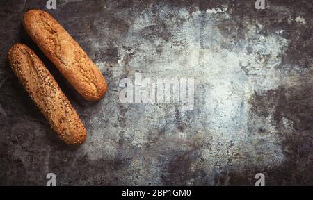 Produits frais de boulangerie. Pains croustillants de pains et petits pains et épis de blé mélangés sur fond rustique de table. Vue de dessus et espace de copie pour le texte. Banque D'Images