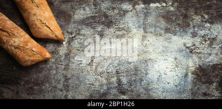 Produits frais de boulangerie. Pains croustillants de pains et petits pains et épis de blé mélangés sur fond rustique de table. Vue de dessus et espace de copie pour le texte. Bannière large Banque D'Images