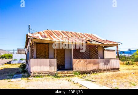 Maison d'angle ancien avec toit en étain Rusty et fenêtres à boargie Banque D'Images