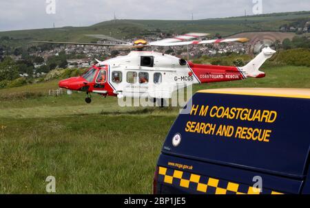 Un hélicoptère AW189 AgustaWestland de HM Coastguard arrive à terre sur le côté de la falaise près de Overcombe à Dorset, pendant un exercice d'entraînement. Banque D'Images