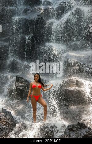 Fille debout à Kanto Lampo Waterfall près d'Ubud Bali Indonésie Banque D'Images
