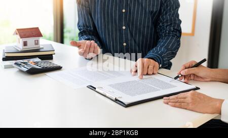 Real estate agents expliquer le document pour les clients qui viennent au contact d'acheter une maison, acheter ou vendre un bien immobilier concept Banque D'Images