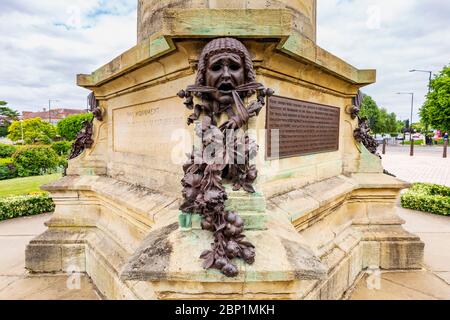 Un masque théâtral grec sur le monument Gower représentant la tragédie avec des coquelicots et des pivoines, Stratford-upon-Avon, Angleterre Banque D'Images