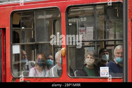 Belgrade, Serbie - 15 mai 2020 : personnes portant un masque chirurgical tout en étant assis et en conduisant dans un siège de fenêtre d'un tramway, de l'extérieur Banque D'Images