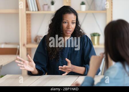 Gros plan une femme d'affaires afro-américaine confiante expliquant les nouvelles responsabilités. Banque D'Images