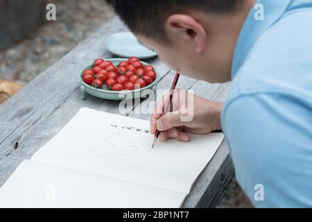 (200517) -- HANGZHOU, 17 mai 2020 (Xinhua) -- Liu Jie travaille sur la réplique de Bakohan dans son studio de Longquan, dans la province de Zhejiang, en Chine orientale, le 7 mai 2020. Liu Jie, 35 ans, et un céramiste de renom à Longquan, a commencé à reproduire Bakohan depuis 2019. Il a jusqu'à présent fait plus de 500 répliques dans un effort pour approcher la perfection. « Je souhaite reproduire sa beauté. » dit Liu. Bakohan est un bol à thé fabriqué à Longquan, en Chine, et offert au Japon pendant la dynastie des Song du Sud (1127-1279). À l'époque de la dynastie Ming (1368-1644), Bakouhan a été trouvé pour avoir des fissures et a ensuite été envoyé en Chine pour être fixé. TH Banque D'Images