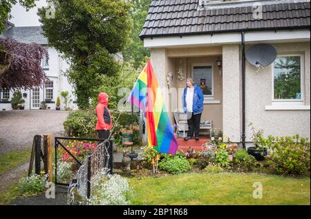 SOUS EMBARGO LE LUNDI 0001 MAI 18. Becs Barker (à gauche) discute avec son voisin Jan Brown à sa porte à Minard, Argyll et Bute. Une poignée de résidents du village ont mis en place un groupe communautaire pour aider les vulnérables à faire du shopping avec la majorité de ceux dans le village qui aident maintenant et dans le processus ont découvert un esprit communautaire renouvelé par leurs efforts pour lutter contre la solitude de confinement. Banque D'Images