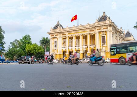 Hanoï, Vietnam - 30 avril 2018 : Opéra, circulation dans la rue et passage d'une moto au premier plan Banque D'Images