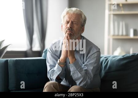 Fidèle homme âgé d'âge moyen priant Dieu. Banque D'Images