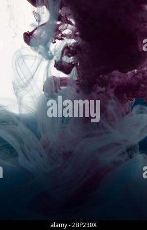 une belle image d'un liquide rose et torquoise coloré se mélangeant dans l'eau, motif abstrait Banque D'Images